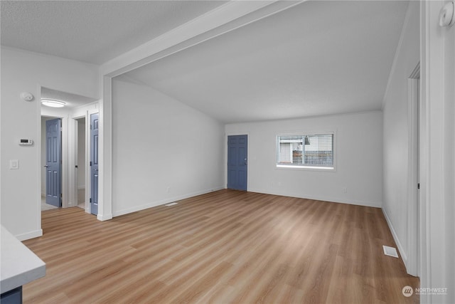 unfurnished living room featuring a textured ceiling and light hardwood / wood-style flooring