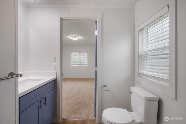 bathroom featuring a textured ceiling, toilet, and vanity