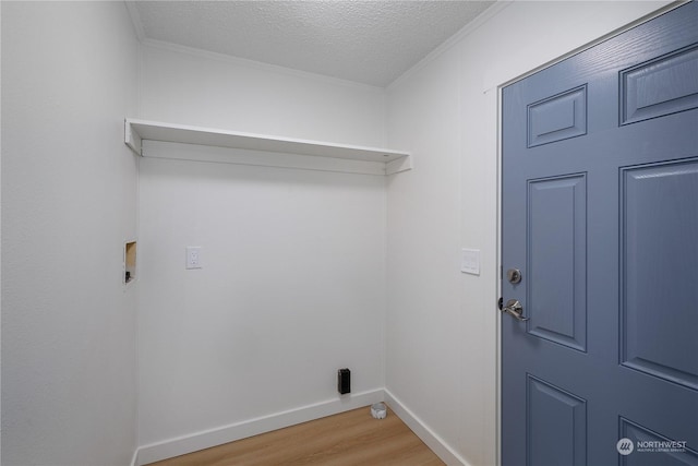 washroom featuring washer hookup, ornamental molding, a textured ceiling, and hardwood / wood-style flooring