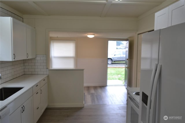 kitchen with white appliances, decorative backsplash, hardwood / wood-style flooring, sink, and white cabinetry