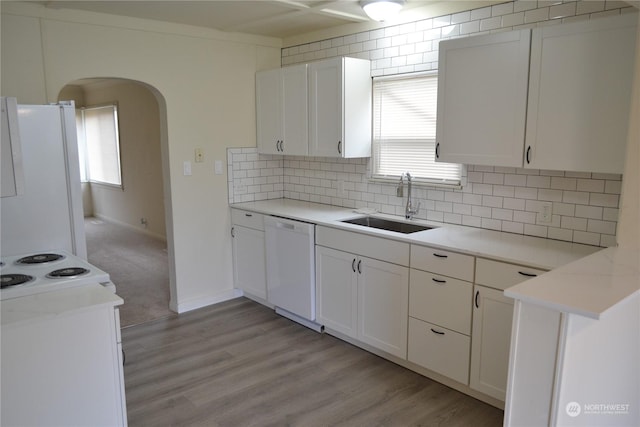 kitchen featuring sink, white appliances, white cabinetry, and a wealth of natural light