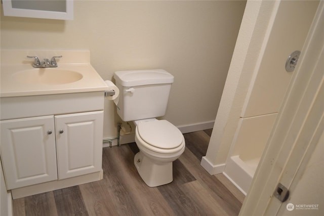 bathroom featuring toilet, vanity, and hardwood / wood-style floors