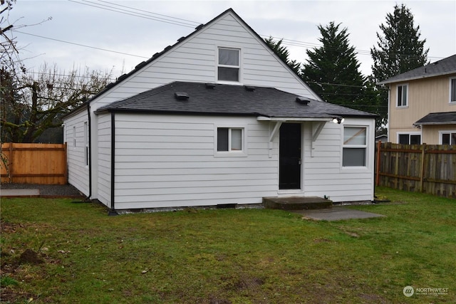 rear view of house featuring a lawn