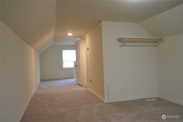 additional living space featuring lofted ceiling and light carpet