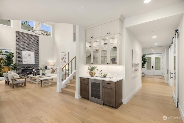 bar with white cabinets, light wood-type flooring, and wine cooler