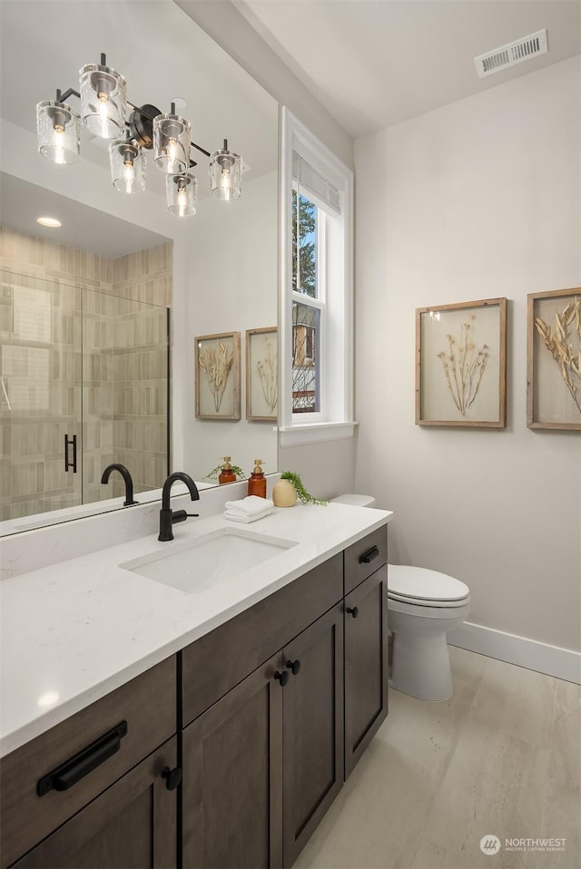 bathroom with toilet, a shower with shower door, and vanity