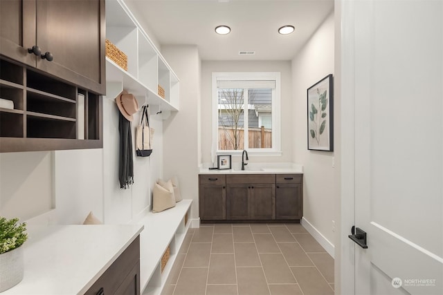 mudroom with sink and light tile patterned flooring