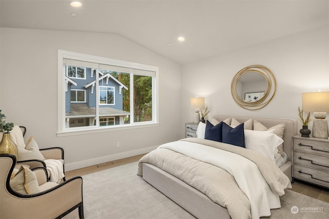 bedroom with light hardwood / wood-style floors and lofted ceiling