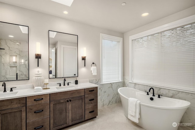 bathroom with tile walls, tile patterned floors, vanity, and a bathing tub