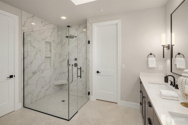 bathroom featuring a shower with door and vanity