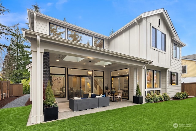 back of property featuring a patio area, a lawn, and an outdoor living space