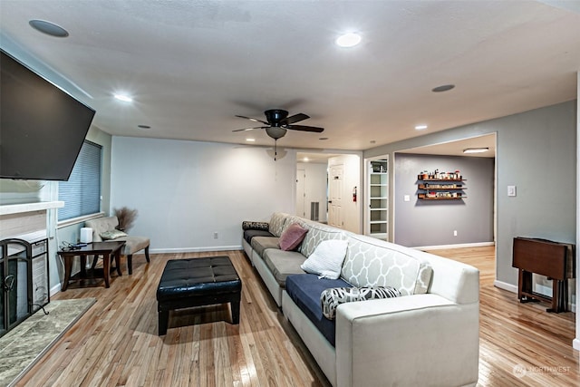 living room featuring ceiling fan, light hardwood / wood-style floors, and built in features