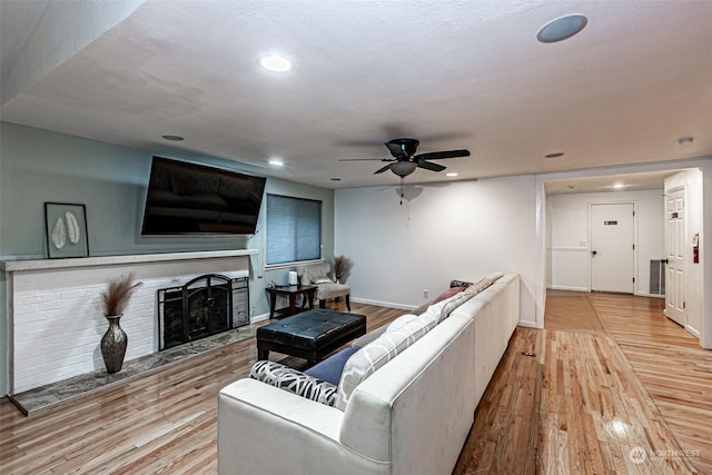 living room featuring ceiling fan and light hardwood / wood-style floors