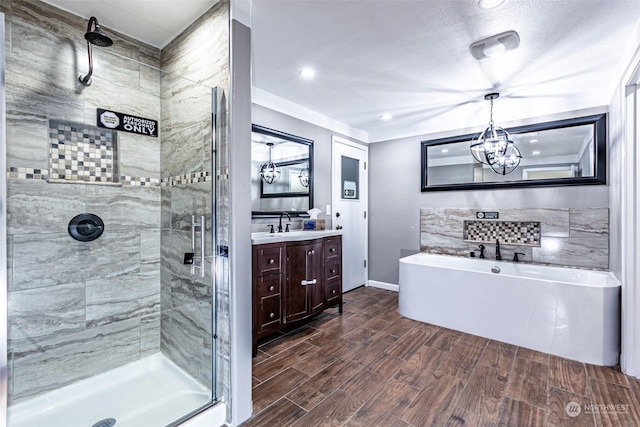 bathroom featuring separate shower and tub, vanity, and a chandelier