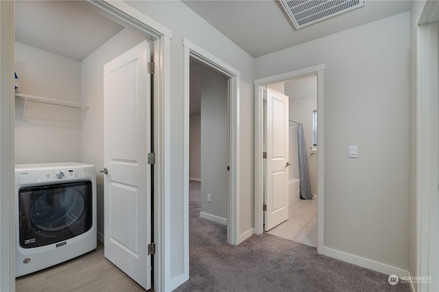 laundry area featuring visible vents, light carpet, washer / clothes dryer, baseboards, and laundry area