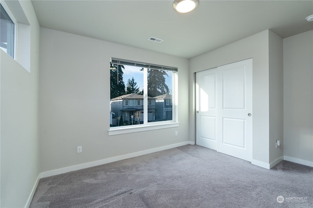 unfurnished bedroom with a closet, visible vents, baseboards, and carpet