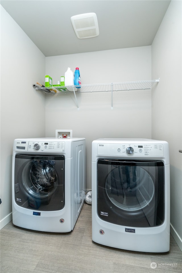 laundry room with laundry area, washer and dryer, and baseboards