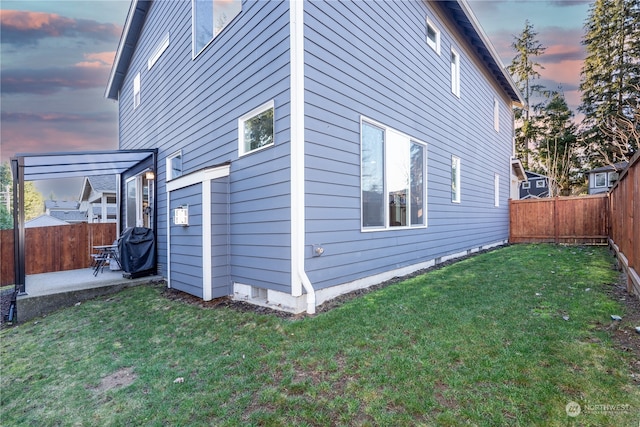 view of property exterior with a yard, a patio, and a fenced backyard