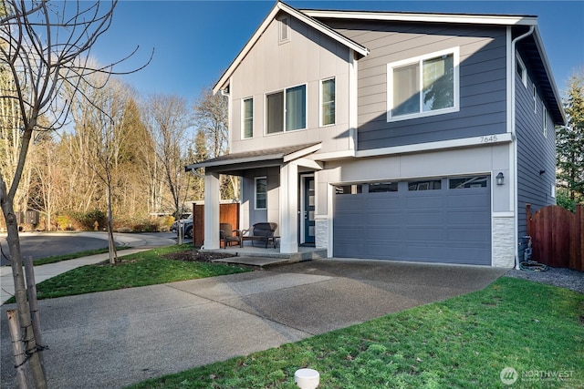 view of front facade featuring stone siding, an attached garage, concrete driveway, and fence