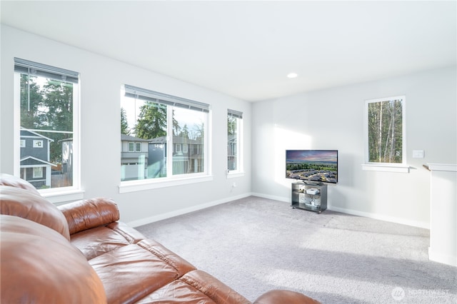 carpeted living area featuring recessed lighting, a healthy amount of sunlight, and baseboards