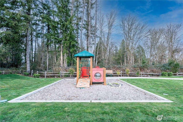 community jungle gym featuring a yard and fence