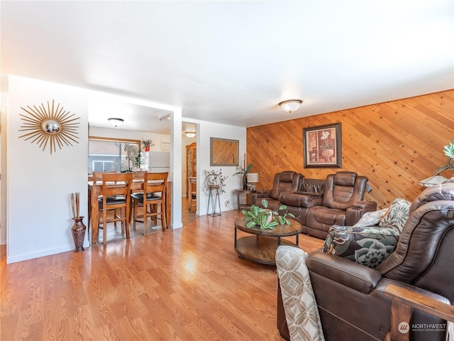 living room featuring light hardwood / wood-style flooring and wood walls