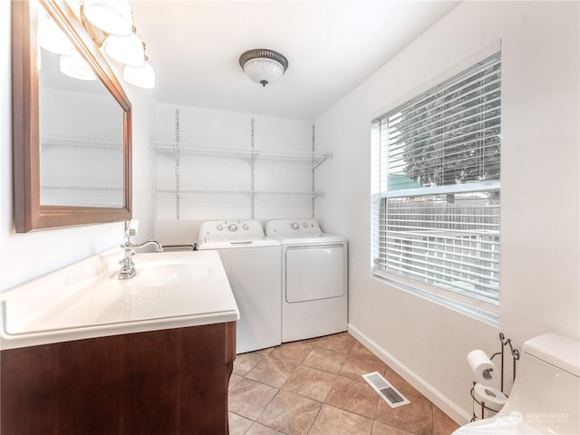 washroom with sink, washer and dryer, and light tile patterned floors