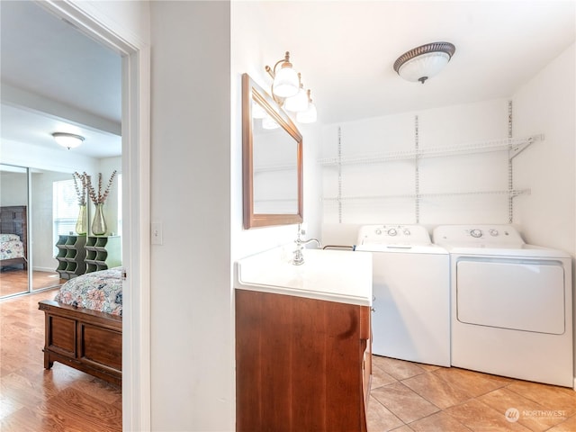 washroom featuring washer and dryer, light tile patterned flooring, and sink