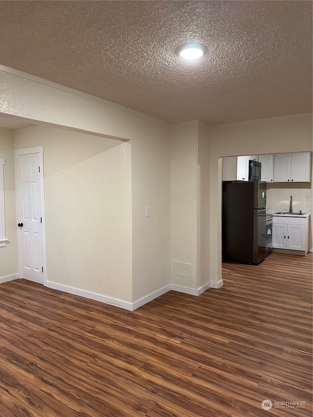 empty room featuring sink, a textured ceiling, and dark hardwood / wood-style flooring