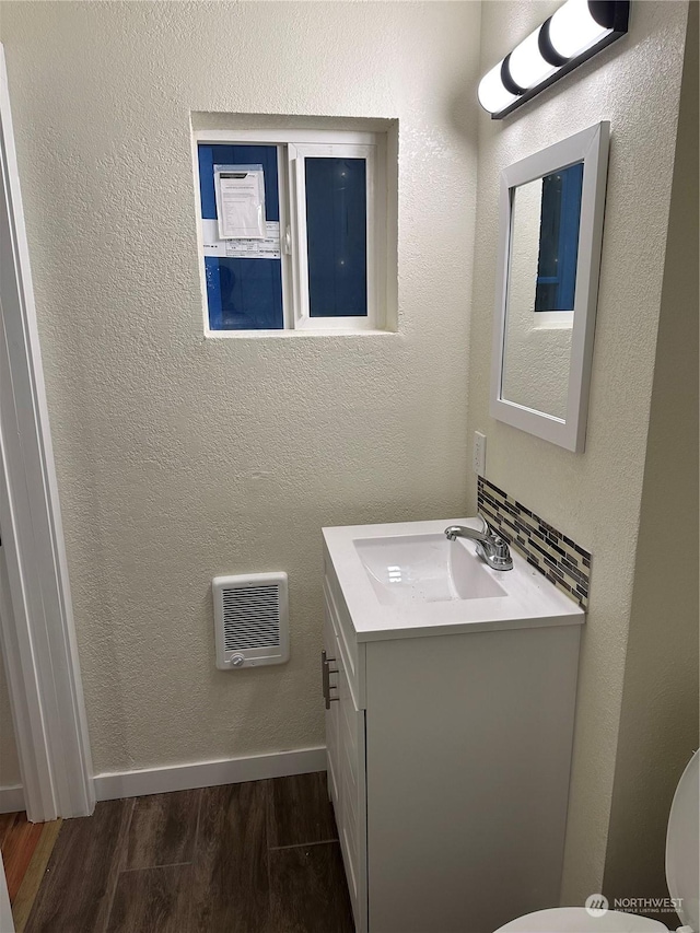 bathroom featuring heating unit, vanity, toilet, and wood-type flooring