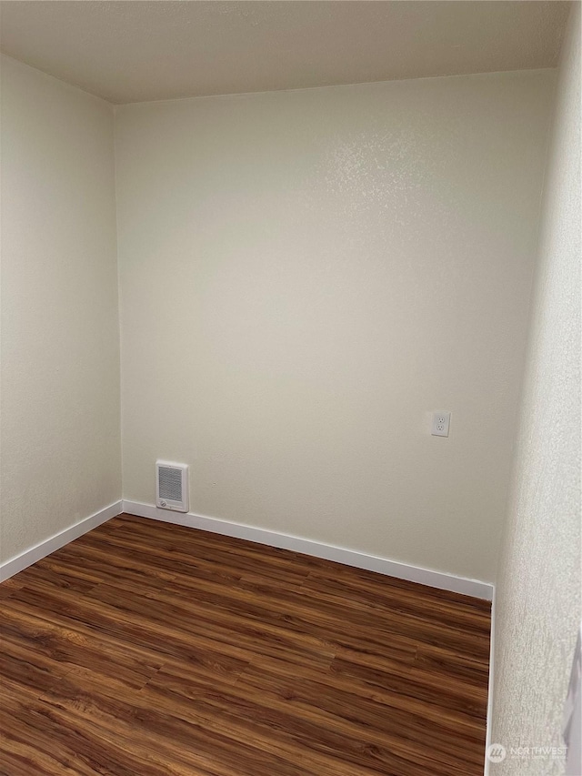 empty room with dark hardwood / wood-style flooring