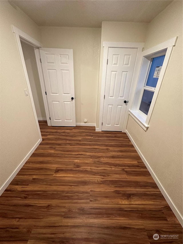 hallway with dark hardwood / wood-style flooring