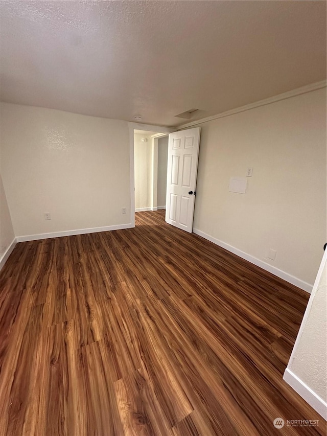 unfurnished room featuring dark hardwood / wood-style flooring and a textured ceiling