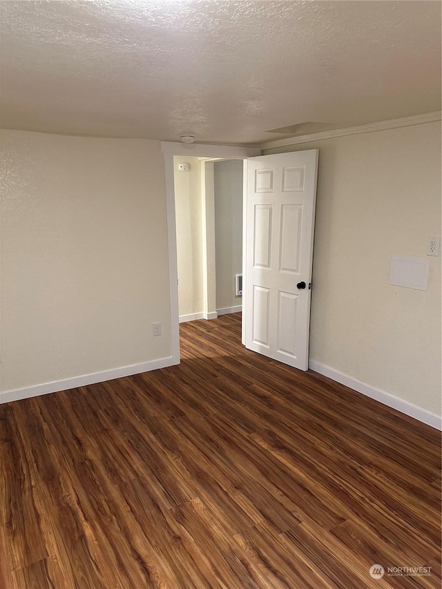 empty room featuring dark hardwood / wood-style flooring and a textured ceiling