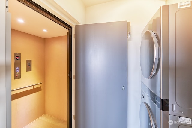 laundry room with elevator and stacked washer and dryer