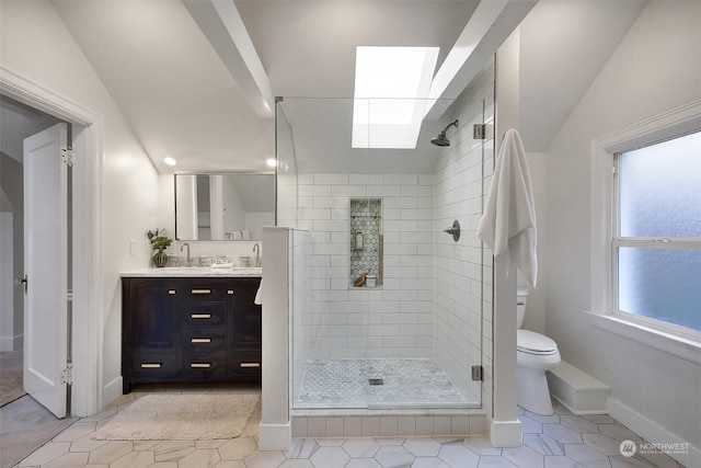 bathroom featuring lofted ceiling with skylight, tile patterned flooring, vanity, and toilet