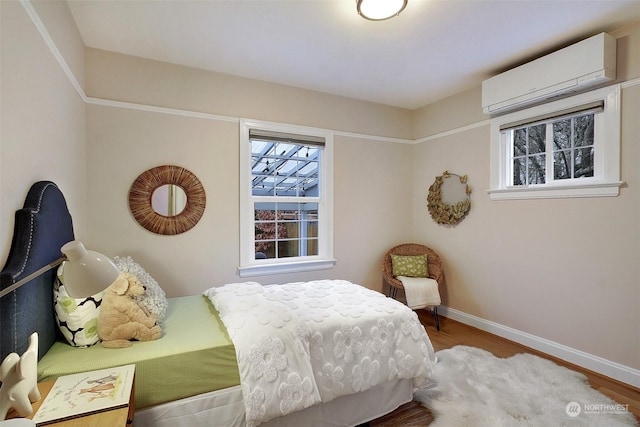 bedroom featuring an AC wall unit and hardwood / wood-style flooring