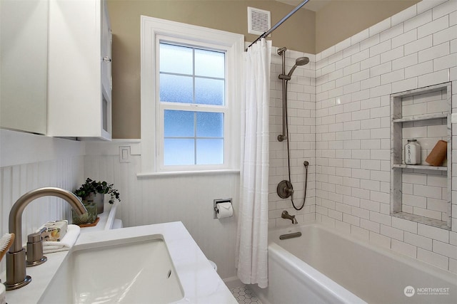 bathroom featuring tile patterned flooring, shower / bath combo with shower curtain, a healthy amount of sunlight, and vanity