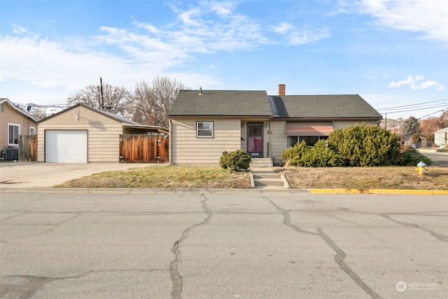 single story home with a garage, central AC unit, an outdoor structure, and a carport