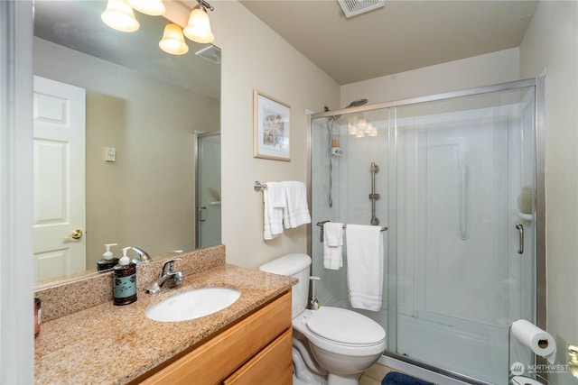 bathroom with toilet, a shower with shower door, and vanity