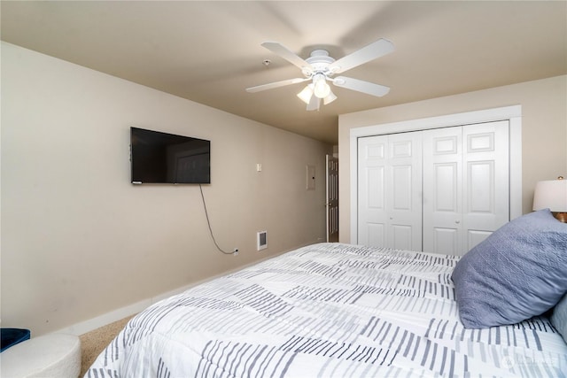 carpeted bedroom with ceiling fan and a closet