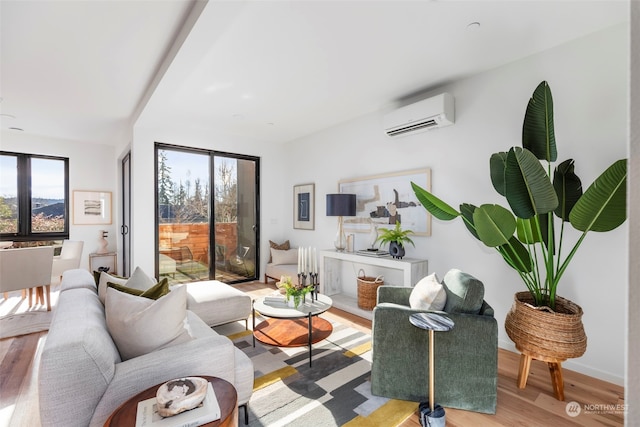 living room with a wall mounted AC, light wood-type flooring, and plenty of natural light