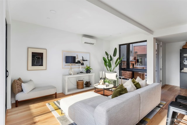 living room with an AC wall unit, beam ceiling, and light hardwood / wood-style floors