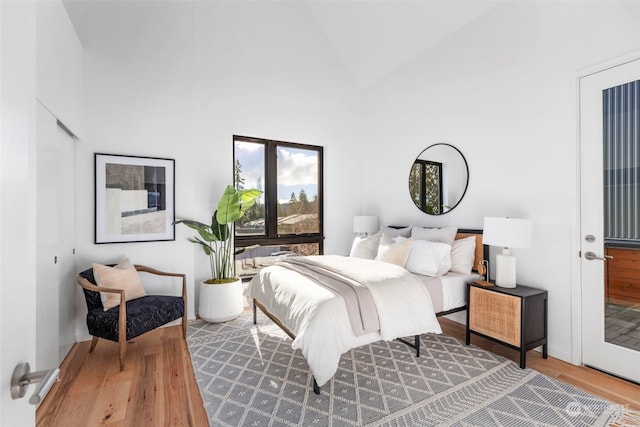 bedroom with hardwood / wood-style flooring and high vaulted ceiling