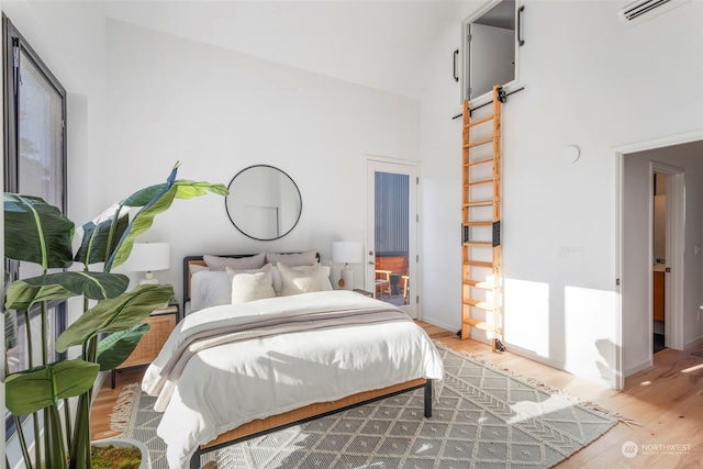 bedroom featuring high vaulted ceiling and hardwood / wood-style flooring