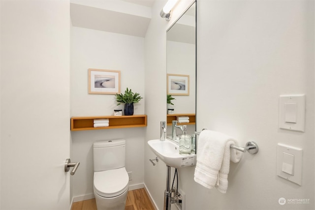 bathroom featuring toilet and wood-type flooring