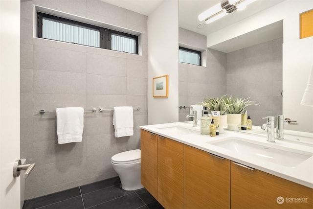 bathroom with vanity, toilet, tile patterned flooring, and tile walls