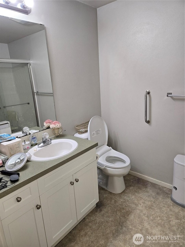 full bathroom with a stall shower, baseboards, vanity, and toilet