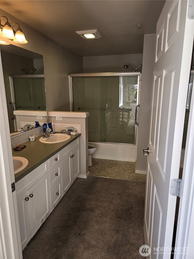 bathroom with double vanity, a sink, and toilet