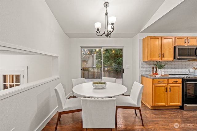 dining area with lofted ceiling, dark wood-type flooring, and a notable chandelier